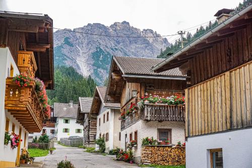 a street in a village with houses and flowers at Stern LODGE im Bergparadies Lechtal in Boden