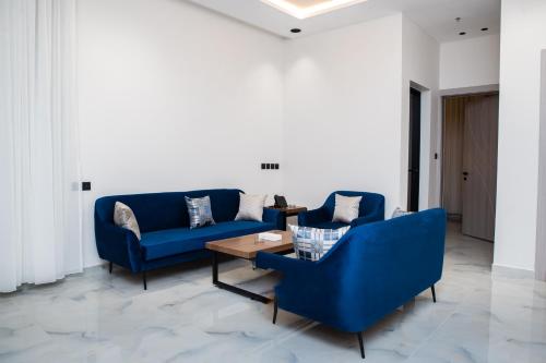 a living room with blue couches and a coffee table at فندق فجر الواحة in Riyadh