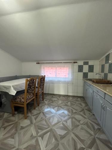 a kitchen with a table and chairs in a room at PENSIUNEA KELEMEN in Praid