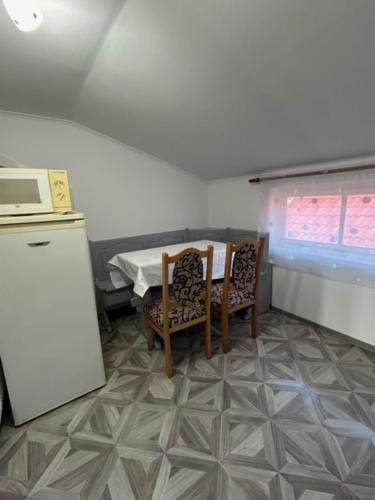 a kitchen with a table and two chairs and a microwave at PENSIUNEA KELEMEN in Praid