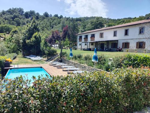 a house with a swimming pool next to a building at Raggiale B&B in San Silvestro
