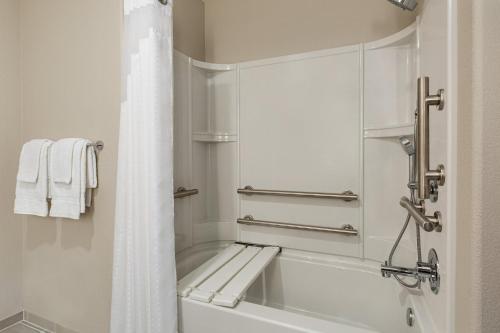 a white bathroom with a tub and a shower at Holiday Inn Express & Suites Hayward - Castro Valley by IHG in Hayward