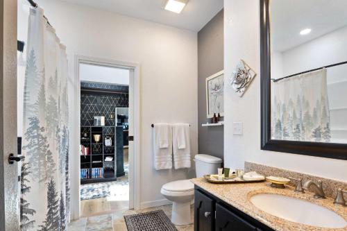a bathroom with a sink and a toilet and a mirror at Hackberry Hideaway - Osage Beach in Montreal