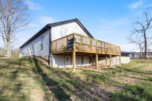 a house with a large deck on the side of it at Hackberry Hideaway - Osage Beach in Montreal