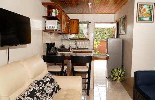a living room with a couch and a kitchen at Departamento Ángeles del Arenal #1 in Fortuna