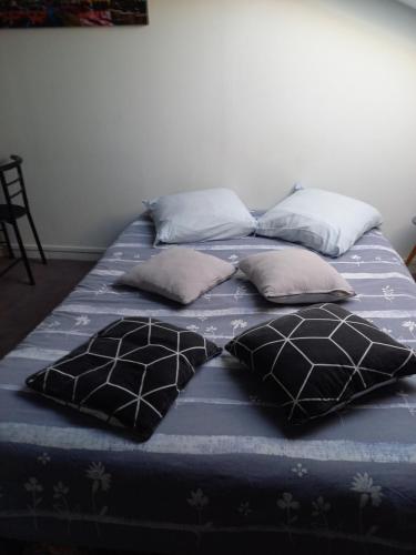 - un grand lit avec des oreillers dans l'établissement Studio, à Oyonnax