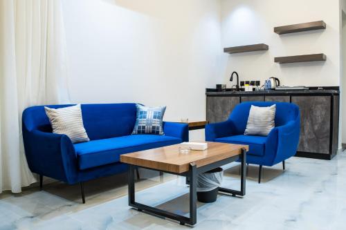 two blue chairs and a table in a room at فندق فجر الواحة in Riyadh