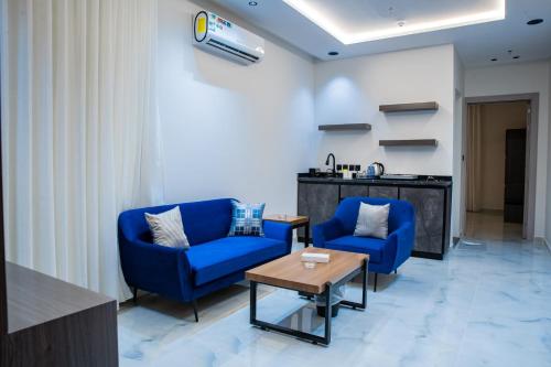 a lobby with two blue chairs and a table at فندق فجر الواحة in Riyadh
