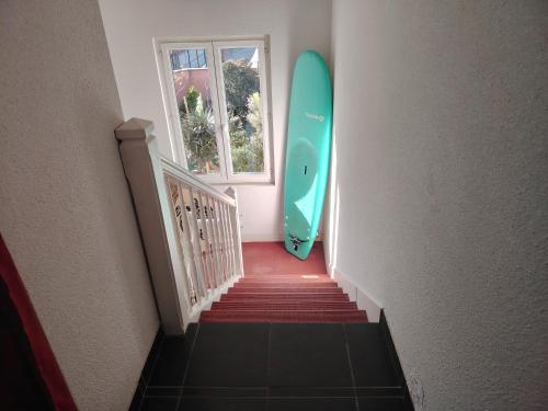 a staircase with a surfboard next to a window at Chambre Suite Zen Baignoire sous les toits in Bénesse-Maremne