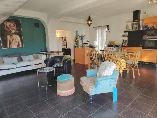 a living room with a couch and chairs and a table at Chambre Suite Zen Baignoire sous les toits in Bénesse-Maremne