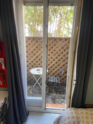 une porte coulissante en verre menant à une terrasse avec une table. dans l'établissement Studio à proximité des Arenes de Nimes, à Nîmes