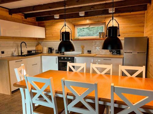 a kitchen with a large wooden table and chairs at Rajska Cisza - całoroczny prywatny domek w lesie nad jeziorem - sauna i balia in Krąg