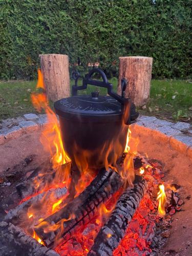 a pot sitting on top of a fire at Rajska Cisza - całoroczny prywatny domek w lesie nad jeziorem - sauna i balia in Krąg