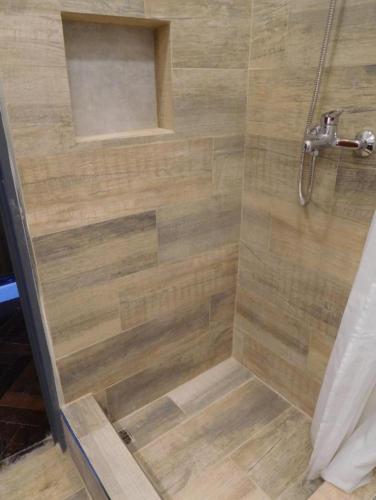a shower in a bathroom with a wooden floor at Apart Fede in Buenos Aires