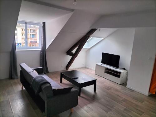 un salon avec un canapé et une télévision dans l'établissement T2 centre ville, à Saint-Nazaire