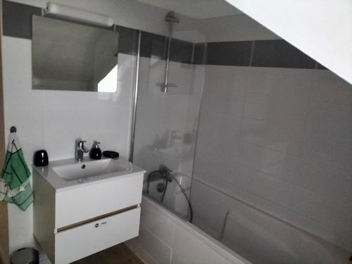 une salle de bain blanche avec une douche et un lavabo dans l'établissement T2 centre ville, à Saint-Nazaire
