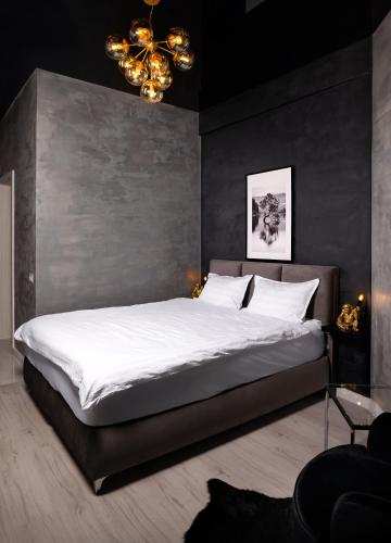 a bedroom with a large bed and a chandelier at Escape Studio Pollux Militari in Dudu