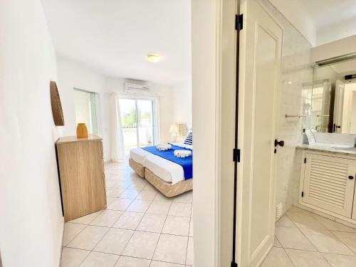 a bedroom with a bed and a bathroom at Albufeira Balaia Golf Vilage 7 With Pool by Homing in Albufeira