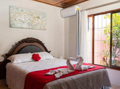 two swans sitting on a bed in a bedroom at Departamento Ángeles del Arenal #2 in Fortuna