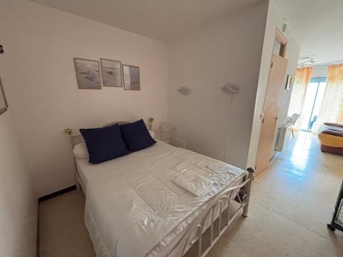 une chambre avec un lit avec des oreillers bleus dessus dans l'établissement Appartement cosy avec balcon à Balaruc-les-Bains, animaux admis - FR-1-503-82, à Balaruc-les-Bains