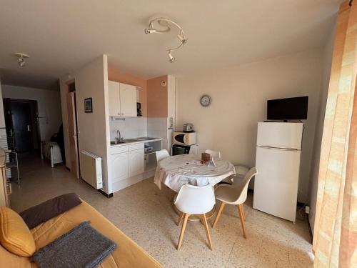 Il comprend un petit salon avec une table et une cuisine. dans l'établissement Appartement cosy avec balcon à Balaruc-les-Bains, animaux admis - FR-1-503-82, à Balaruc-les-Bains