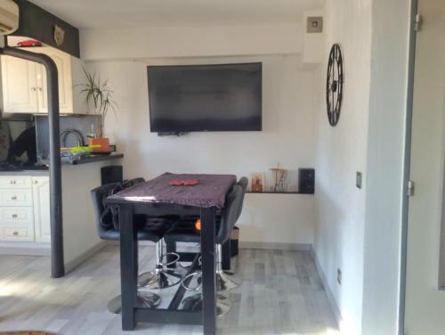 Il comprend une cuisine avec une table et une télévision murale. dans l'établissement Charmant duplex, à Leucate-Plage