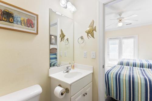 a bathroom with a sink and a mirror at Oceanview 4BR/4BA Condo, Steps to Beach/Pool in Ocean Isle Beach