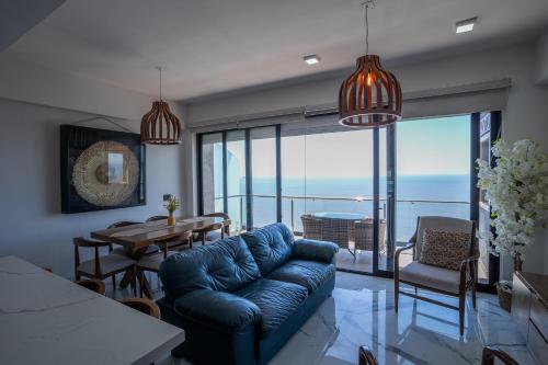 a living room with a blue couch and a table at Mazatlán departamento por malecon in Mazatlán