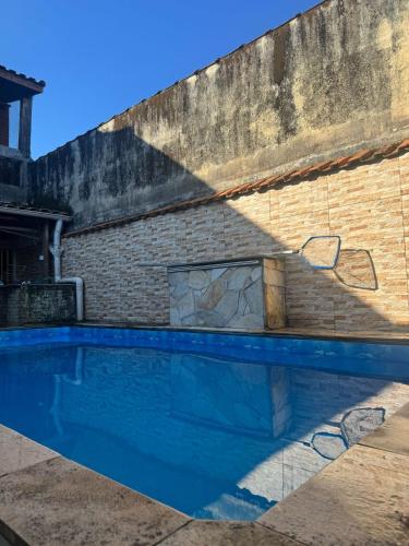 einem Pool vor einem Backsteingebäude in der Unterkunft Casa na Praia 013 in Itanhaém