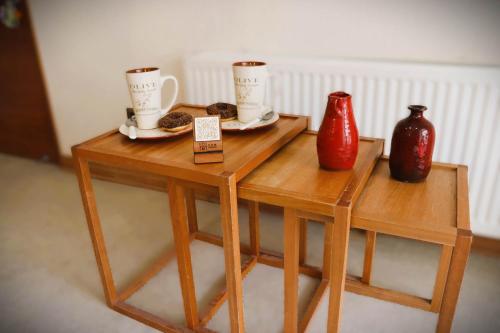 two wooden tables with two cups and vases on them at HOM I Studio SKI OUT 3PAX en Valle de Condores 1 in Farellones