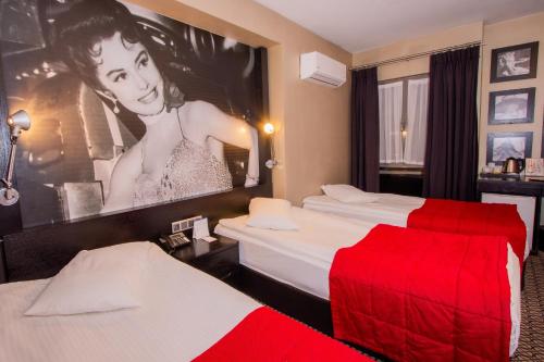 a hotel room with two beds and a poster of a woman at Maltepe 2000 Hotel in Ankara