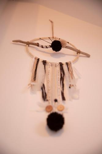 a dream catcher hanging on a white wall at Le Chat Blanc Gîte in Versols-et-Lapeyre