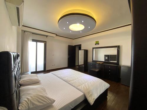 Un dormitorio con una cama grande y un espejo. en مكانك - MakanK, en Seis de Octubre