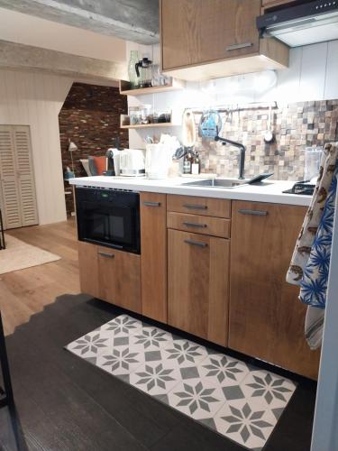 une cuisine avec un évier et une cuisinière dans l'établissement La petite cabane du pecheur, à Honfleur