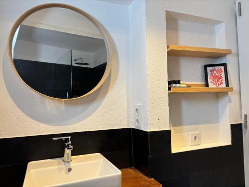 a bathroom with a white sink and a mirror at Apt Es Poal - Des Puig in Cadaqués