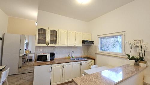 a kitchen with white cabinets and a white refrigerator at Appartamento da Vjeri in Pula