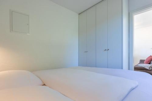 a white bed in a room with a window at Ferienhaus Rügenblick in Stahlbrode