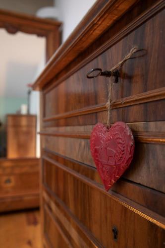 a heart hanging on the side of a wooden wall at Le Chat Blanc Gîte in Versols-et-Lapeyre