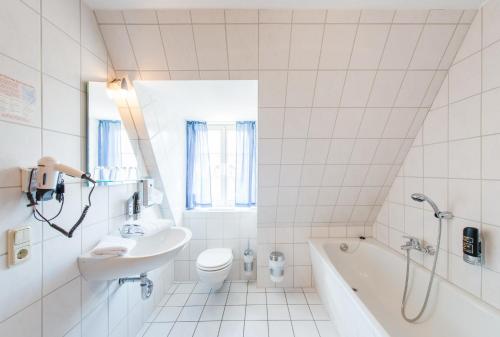 a bathroom with a sink and a toilet and a tub at Maria Aurora in Quedlinburg