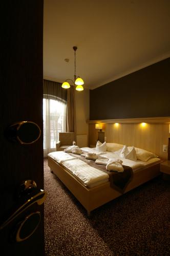 a bedroom with a large bed with white sheets and pillows at Xavin Wellness Hotel & Restaurant in Harkány