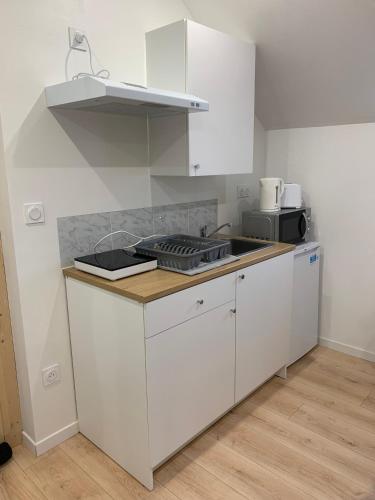 a kitchen with white cabinets and a counter top at Studio guingamp in Guingamp