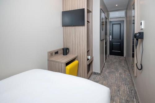 a hotel room with a bed and a television at Brit Hotels Earls Court in London