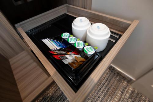 a shelf with two bottles of milk and some snacks at Brit Hotels Earls Court in London