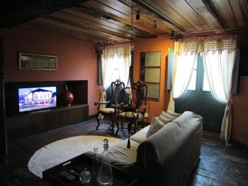 a living room with a couch and a tv at Hotel Quadrado in Santa Bárbara