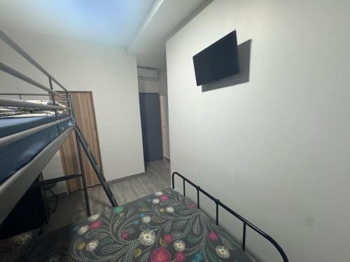 escalera con sofá y TV en la pared en Faculte Hotel, en Marsella