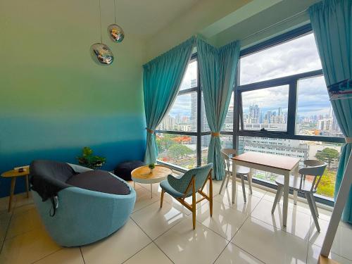a living room with a blue couch and a table and a large window at 3 Towers Jalan Ampang By Serenity Vacation Homes in Kuala Lumpur