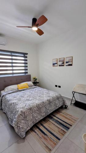 a bedroom with a bed and a ceiling fan at Mountain View Penthouse Condo in Muñoz