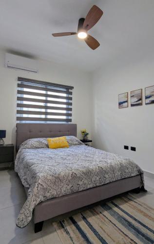 a bedroom with a bed and a ceiling fan at Mountain View Penthouse Condo in Muñoz