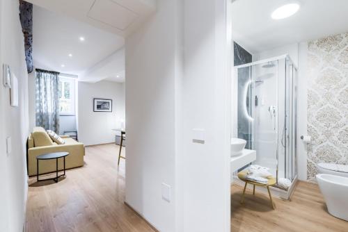 a white bathroom with a shower and a sink at History and Design Apartment Facing the Old Port in Genova