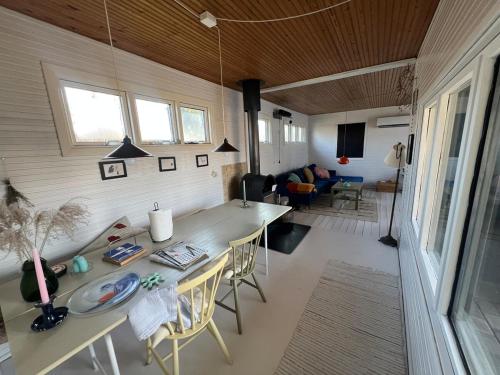 a room with a table and chairs and a living room at House with lovely garden and close to water with Shelter in Kirke-Hyllinge